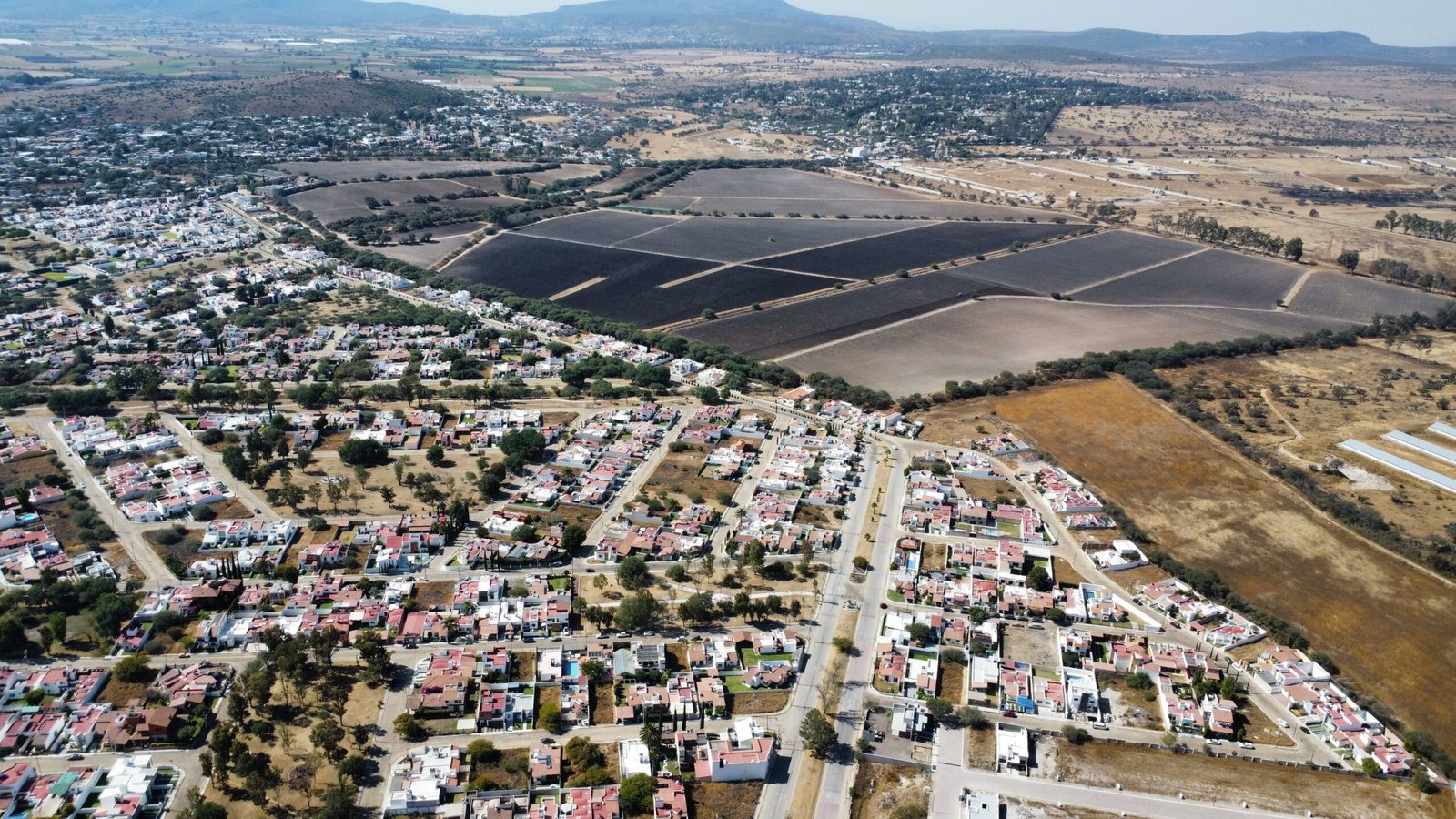 Panoramic aerial view of a town and fields in the Mexican countryside on a sunny day.